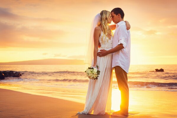 Foto di matrimonio sullo sfondo del mare al tramonto