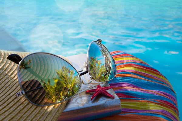 Occhiali da sole e una stella a bordo piscina