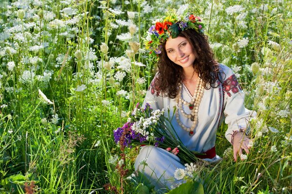 La jeune fille avec une couronne sur la tête, assis dans l herbe