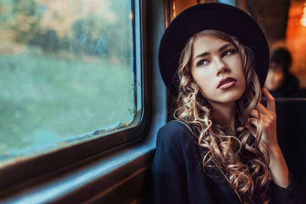 Hermosa chica con sombrero y en el metro