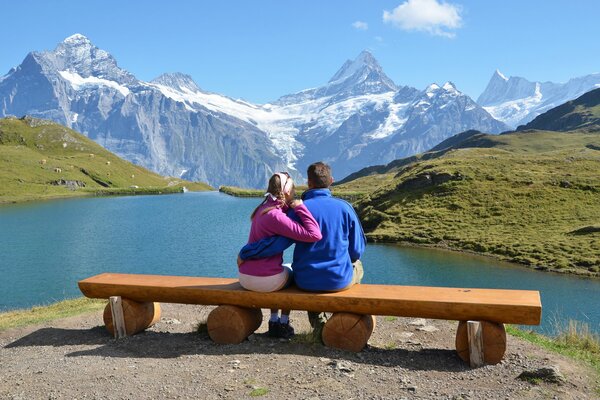 La coppia si siede su una panchina e guarda le montagne