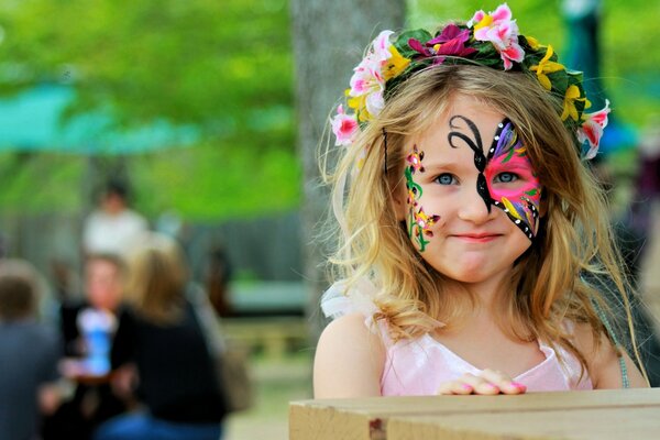 Une fille avec un visage peint dans une couronne