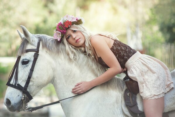 Nelly Lehtinen con una corona en la cabeza montando un caballo blanco