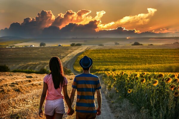 Un couple marche sur le terrain vers les nuages