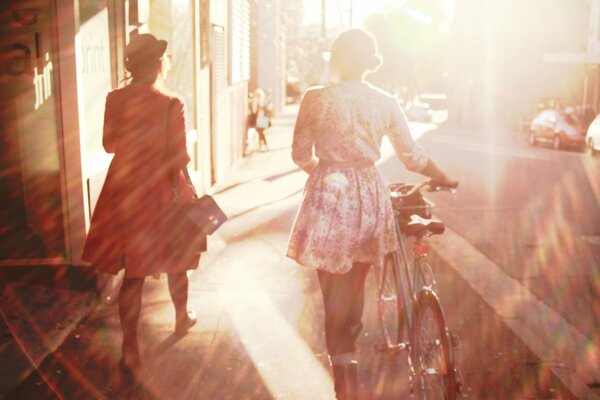 Mädchen mit Fahrrad auf einer sonnigen Straße