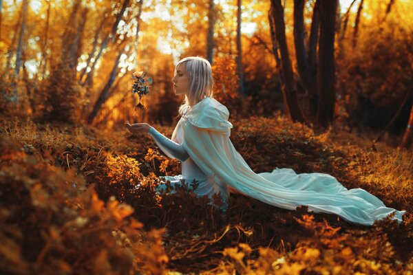 Ragazza nella foresta con una rosa in mano