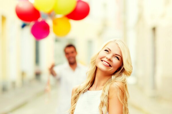 A shy girl with balloons and a man