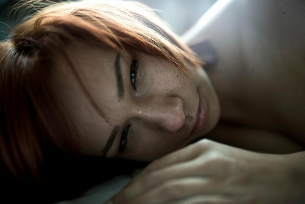The red-haired girl is crying. The girl is depressed. Square for redheads