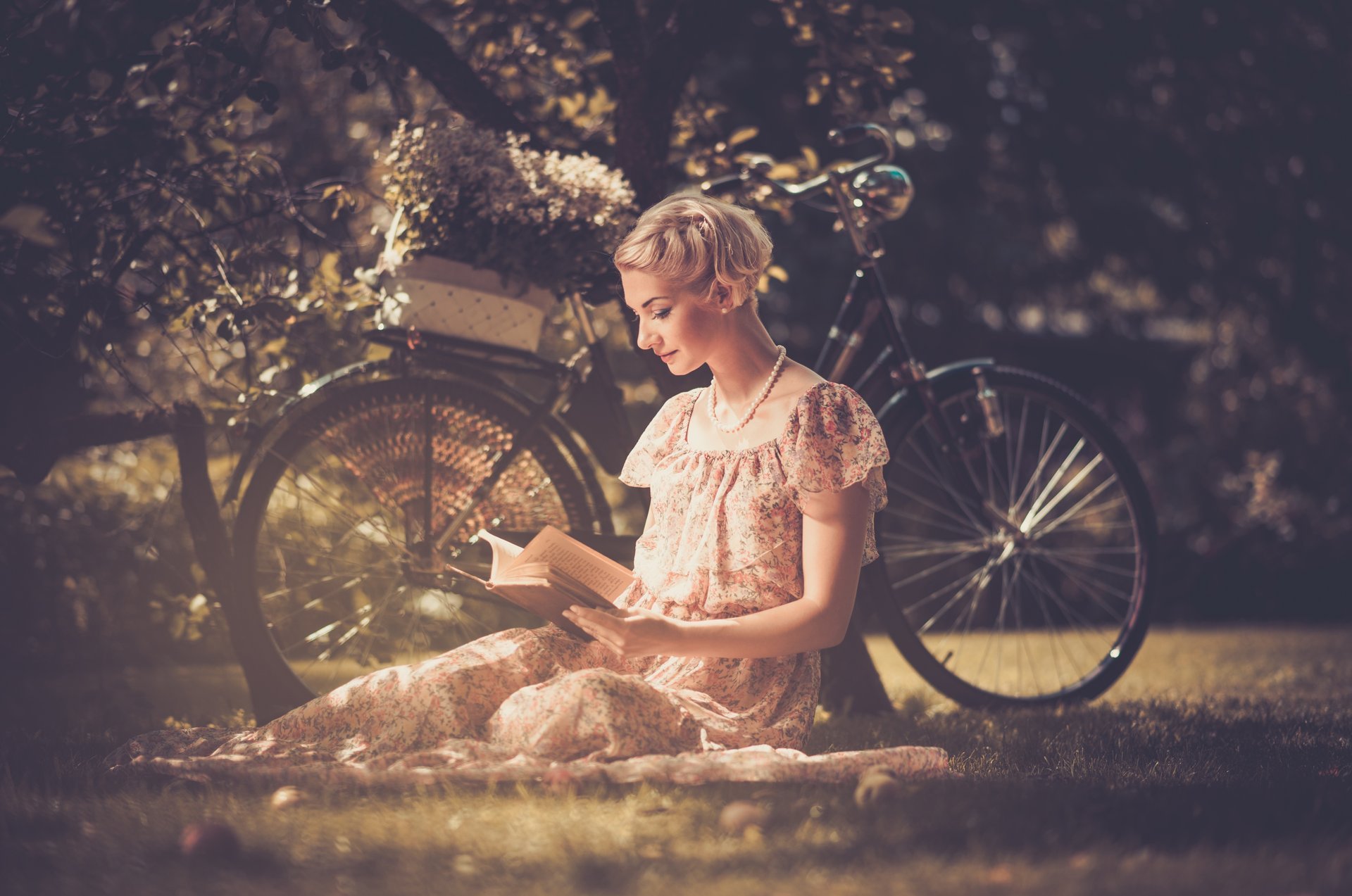 mädchen blond kleid perlen stil retro buch liest gras fahrrad korb blumen baum blätter natur