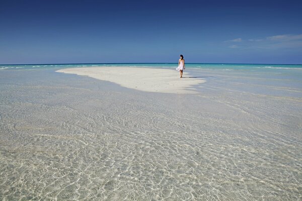 Fille marche sur le sable blanc