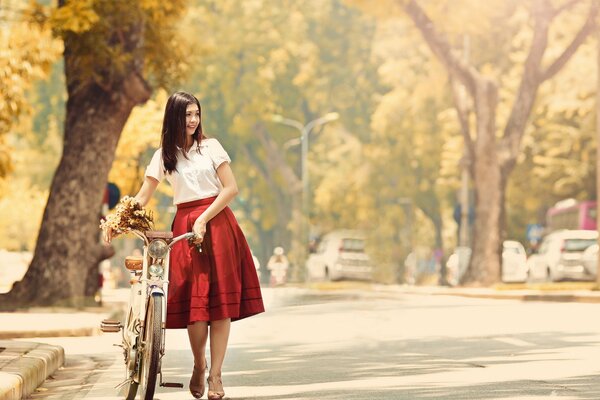 Chica en falda roja en bicicleta