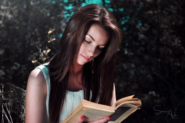 Fille aux cheveux noirs lit un livre