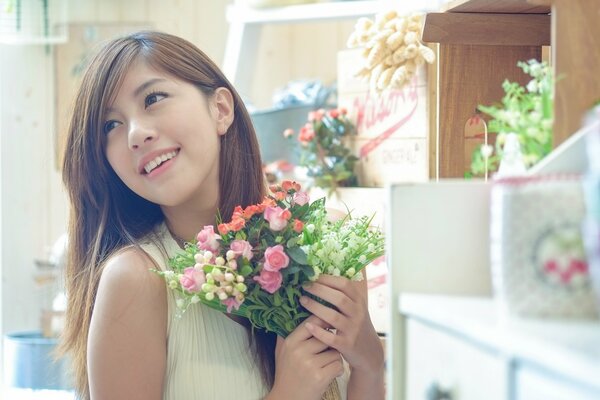 Chica asiática con un ramo de flores