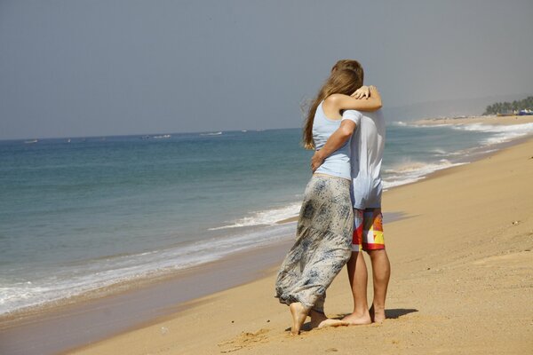 Guy and girl hugging on the ocean