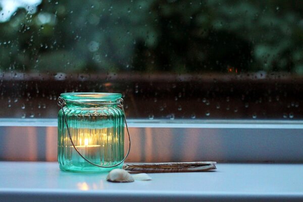 Lampade sul davanzale di una candela in un barattolo