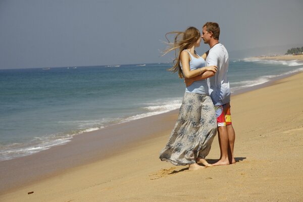 A couple in love stands on the seashore