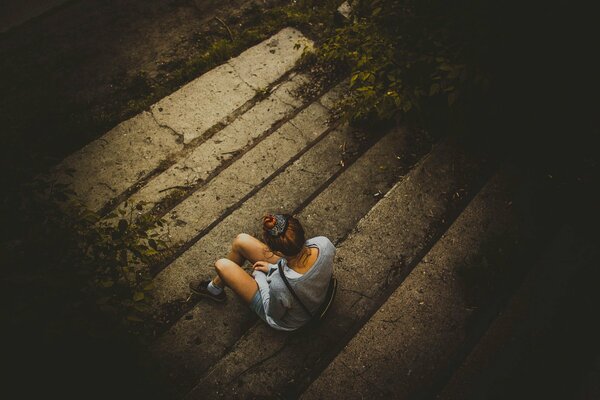 A lonely girl is sitting on the steps