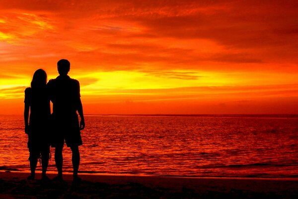 Pareja romántica en una puesta de sol roja