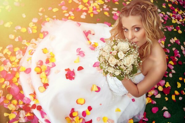 Водоемедевушка dans une robe de mariée avec un bouquet de fleurs