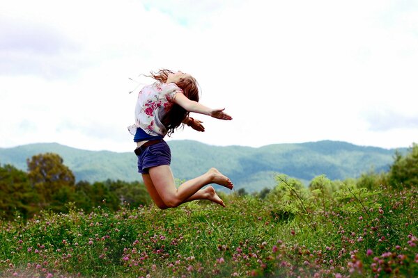 Das Mädchen springt, um eine Stimmung von Leichtigkeit und Freiheit zu vermitteln