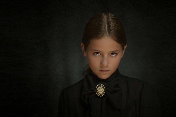 Piercing gaze of a girl with a brooch