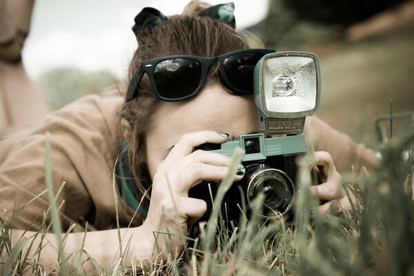 La jeune fille avec un vieil appareil photo dans la nature, dans le champ