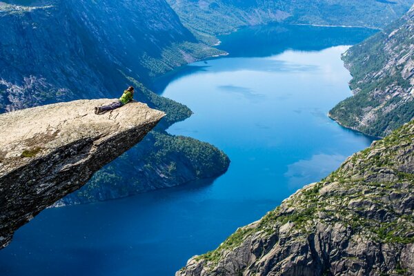 The girl examines the landscape from the cliff