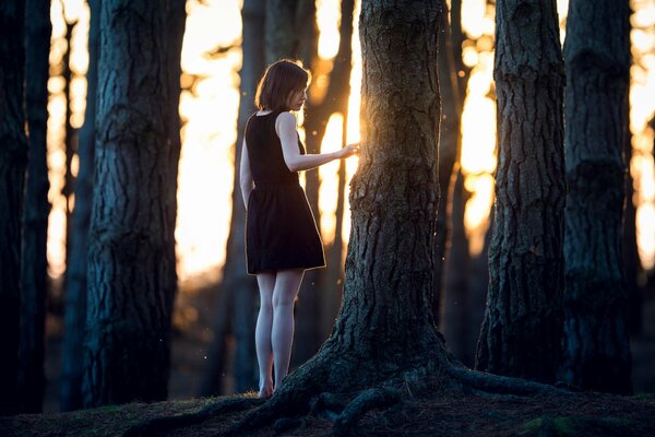 Ragazza in abito nero vicino all albero