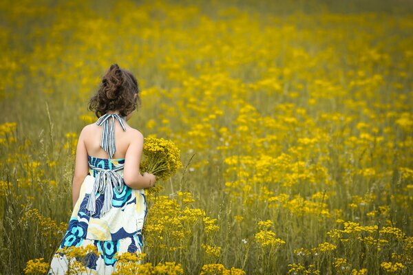 Mädchen in einem leichten Kleid mit einem Blumenstrauß unter den Blumen