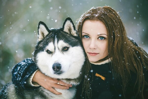 Ragazza con gli occhi azzurri e cane husky