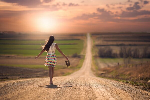 Fille aux pieds nus va sur la route