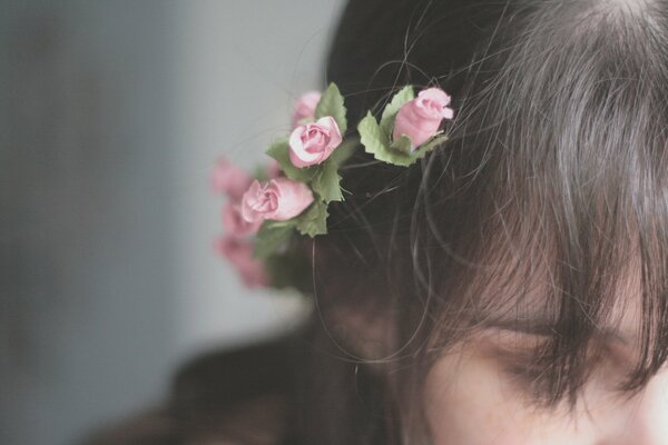 Hermosas flores en el cabello de una niña triste