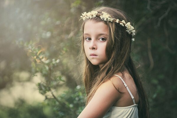 Humeur triste et le regard de la jeune fille sur fond d écran large. Couronne de fleurs sur la tête d une fille