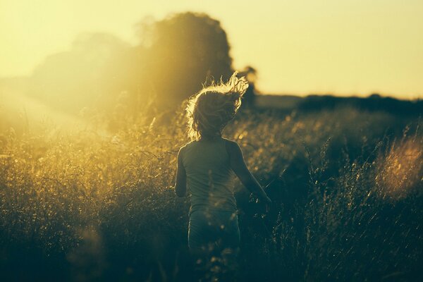 La niña corrió por la hierba