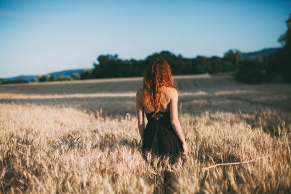 Red-haired girl looks into the field