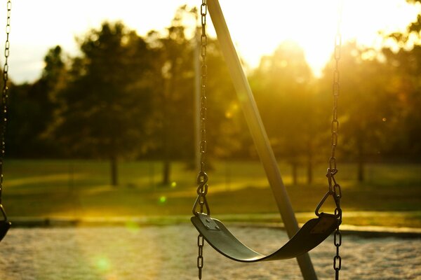 The swing is hanging and the rising sun is visible