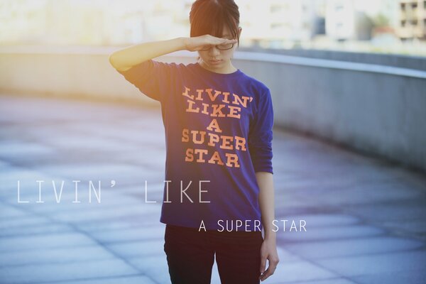 A girl in a blue T-shirt with a print live like a super star