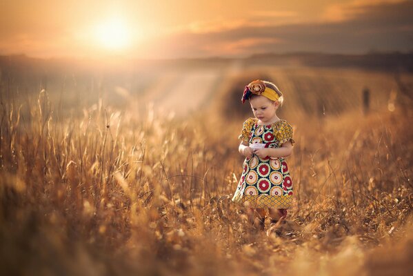 A girl in a patterned dress admires the spikelets