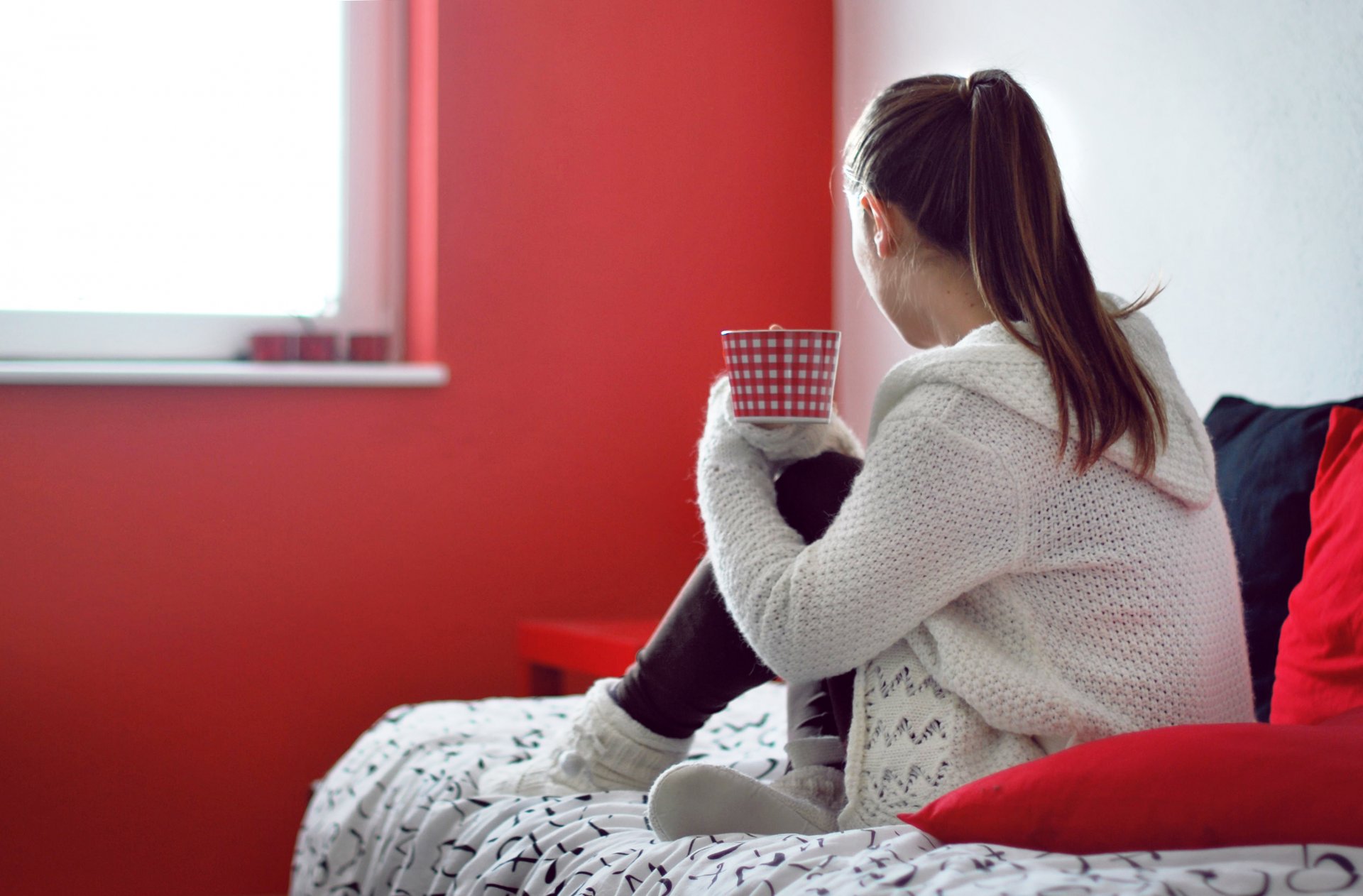 stimmung mädchen brünette jacke gestrickt zuhause gemütlichkeit kissen rot bett krippe becher tasse tee wärme hintergrund tapete widescreen vollbild widescreen widescreen