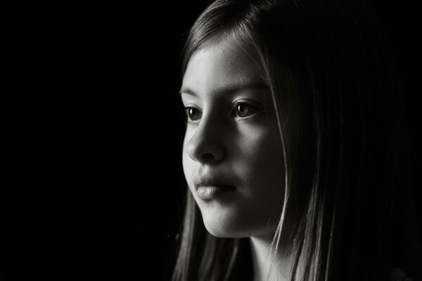 Black and white photo of a girl s face looking into the distance