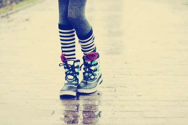 Ragazza in scarpe da ginnastica sull asfalto bagnato