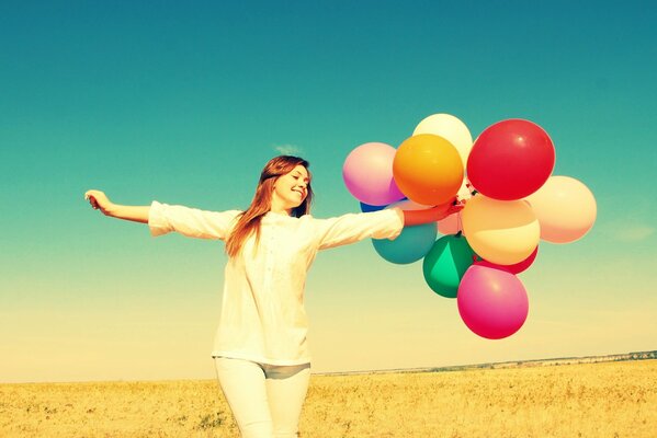 Fille heureuse avec des ballons sur fond de nature