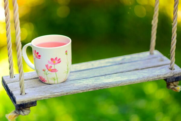 Tasse auf einer Schaukel auf einem unscharfen Hintergrund