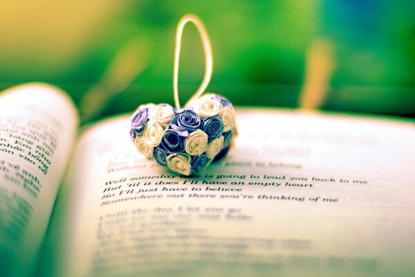 The figure of a heart made of flowers on the background of an open book