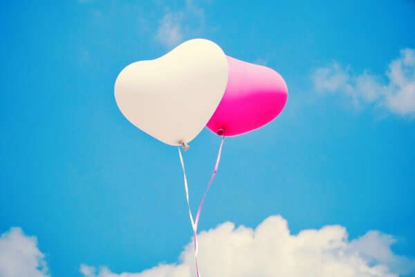 Heart-shaped balloons on a blue sky background