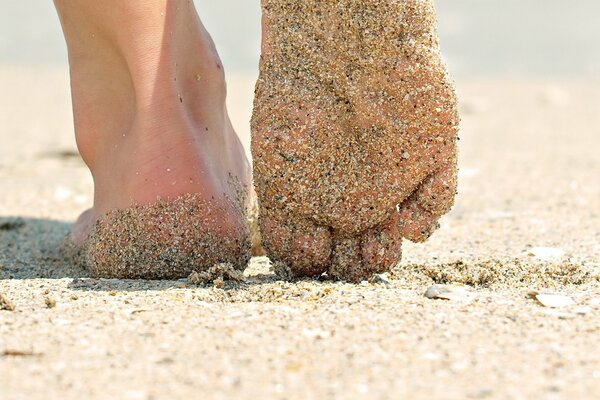 Gehen Sie bei sonnigem Wetter durch den Sand