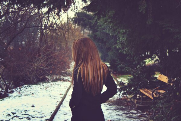 Mädchen mit langen Haaren im Winter an der Bank