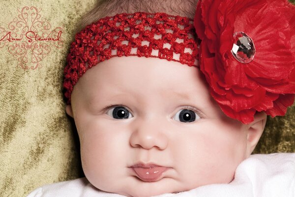 Una niña en una diadema con un lazo rojo