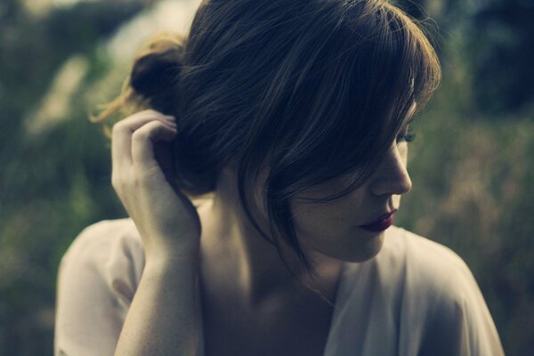 Thoughtful girl on the background of grass