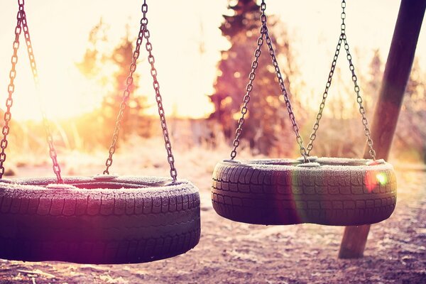 The swing in the form of tires is suspended on chains